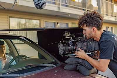 Camerman filming woman in car for film industry